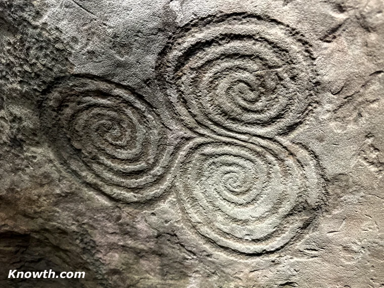 Triple spiral carved on orthostat C10 in the back recess of the Newgrange chamber.