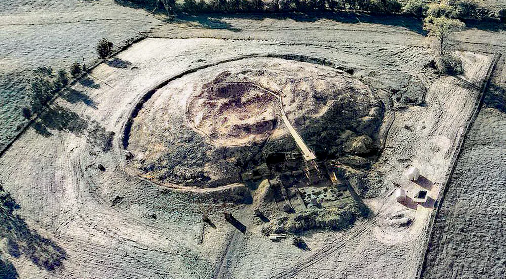 Photograph by Leo Swan of excavation work at Newgrange in the early 1960s with open trenches around the mound.