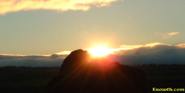 The winter solstice sunrise behind a Newgrange standing stone